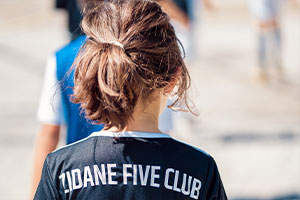 Une jeune fille de dos portant le maillot du ZFC